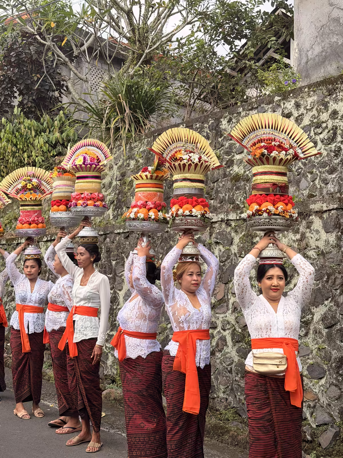 Village women carrying ceremonial offerings through Bakbakan, Gianyar.